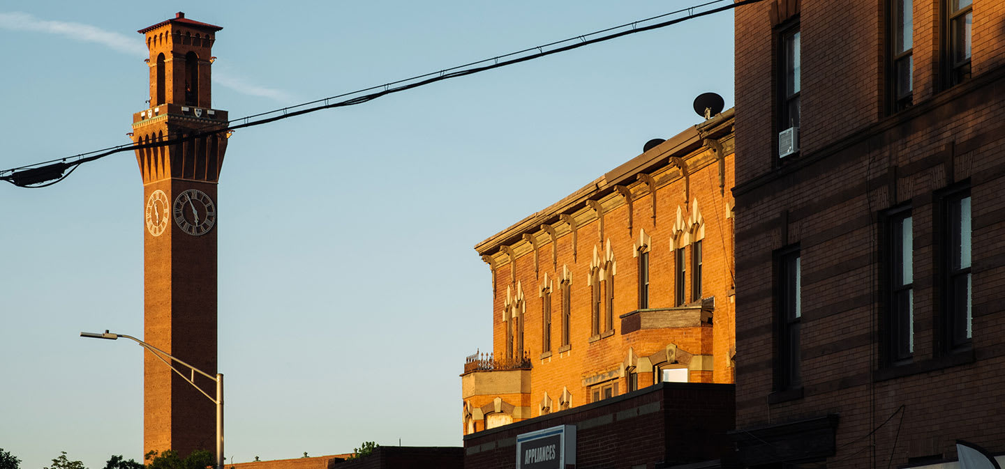 Yellow train on tracks with American Flag on side of it and Timex Banner